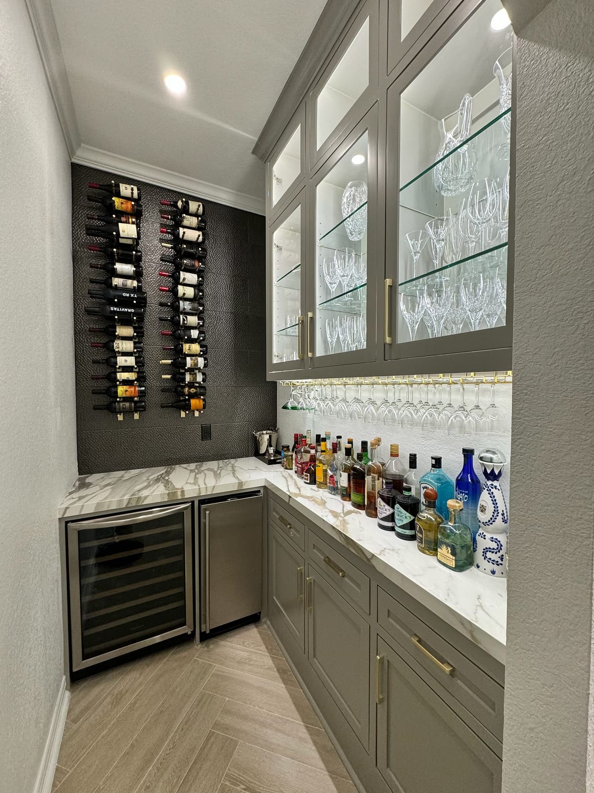 Wet bar and butler's pantry with marble counters and wine wall